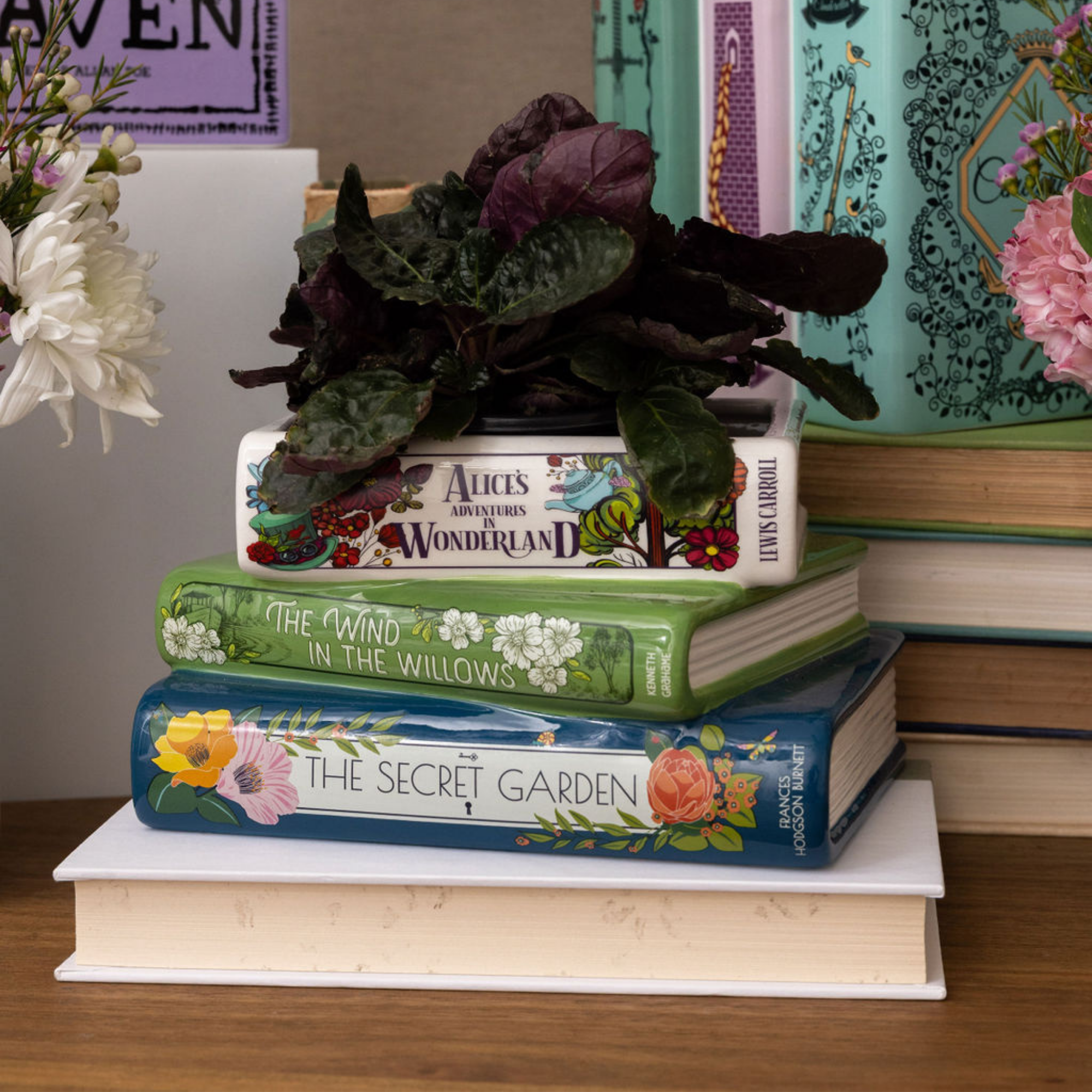 Stack of books with decorative covers on a white background with a plant inside