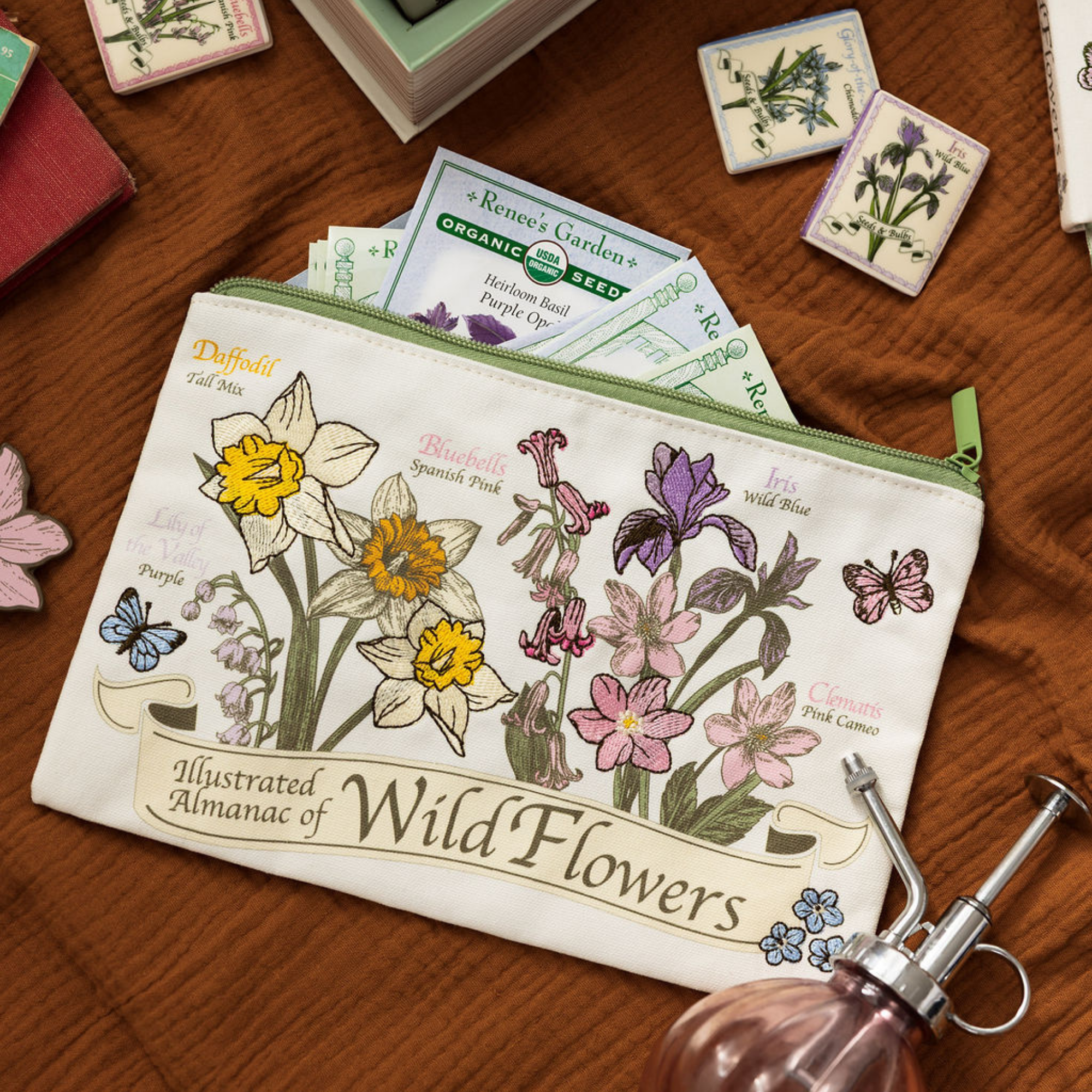 Pouch with floral design and seed packets on a wooden surface