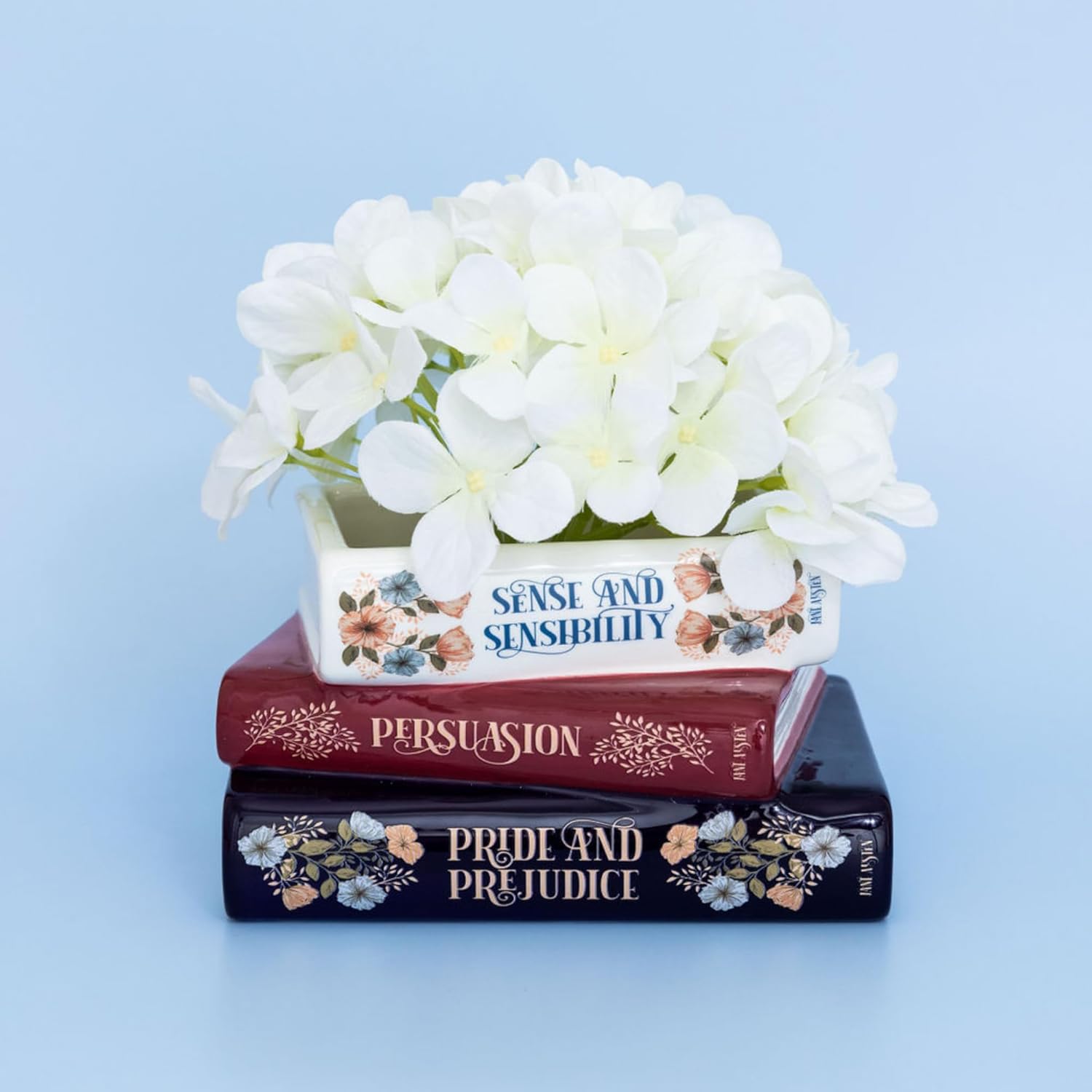 stacked book planter with white flowers inside