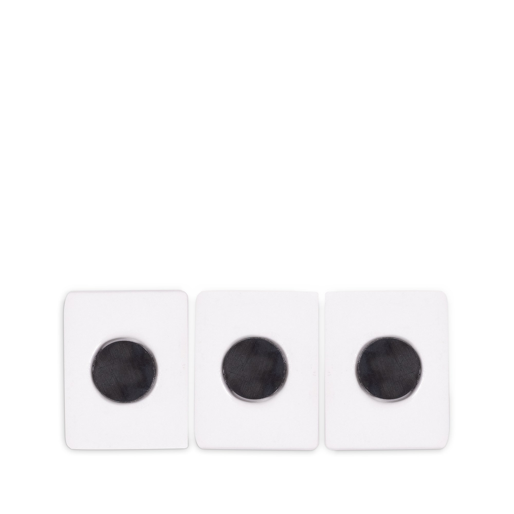 Three white square magnets with circular black centers, arranged side by side on a plain white background.