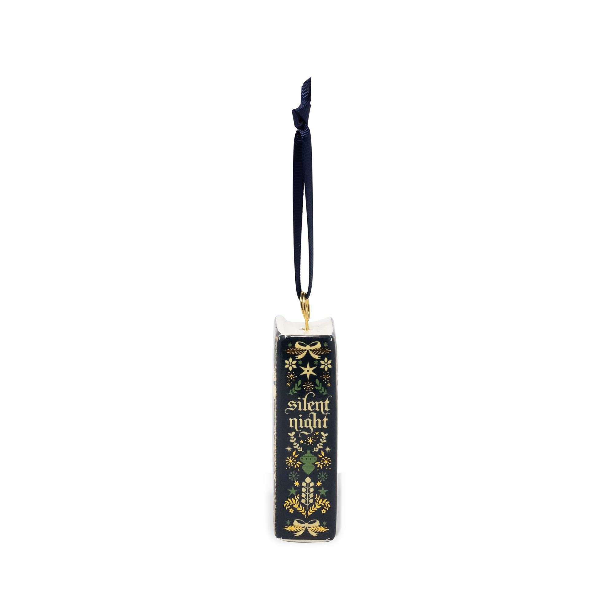 A Christmas ornament shaped like a closed book with a navy blue hanging ribbon. The book cover is dark green with gold and green holiday illustrations and the words 'silent night' in gold lettering.