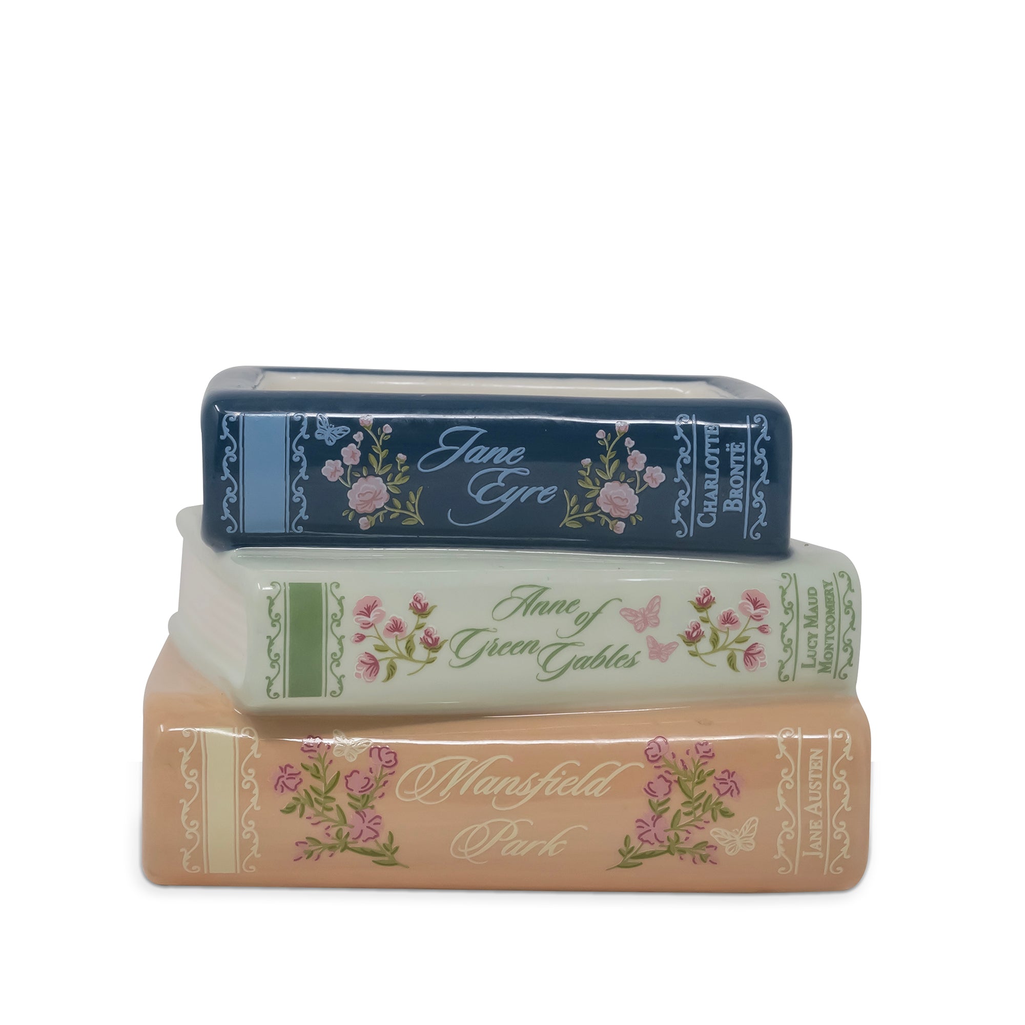 Three decorative book-shaped candle stacked vertically on a white background, featuring floral designs and titles including Jane Eyre, Anne of Green Gables, and Mansfield Park.