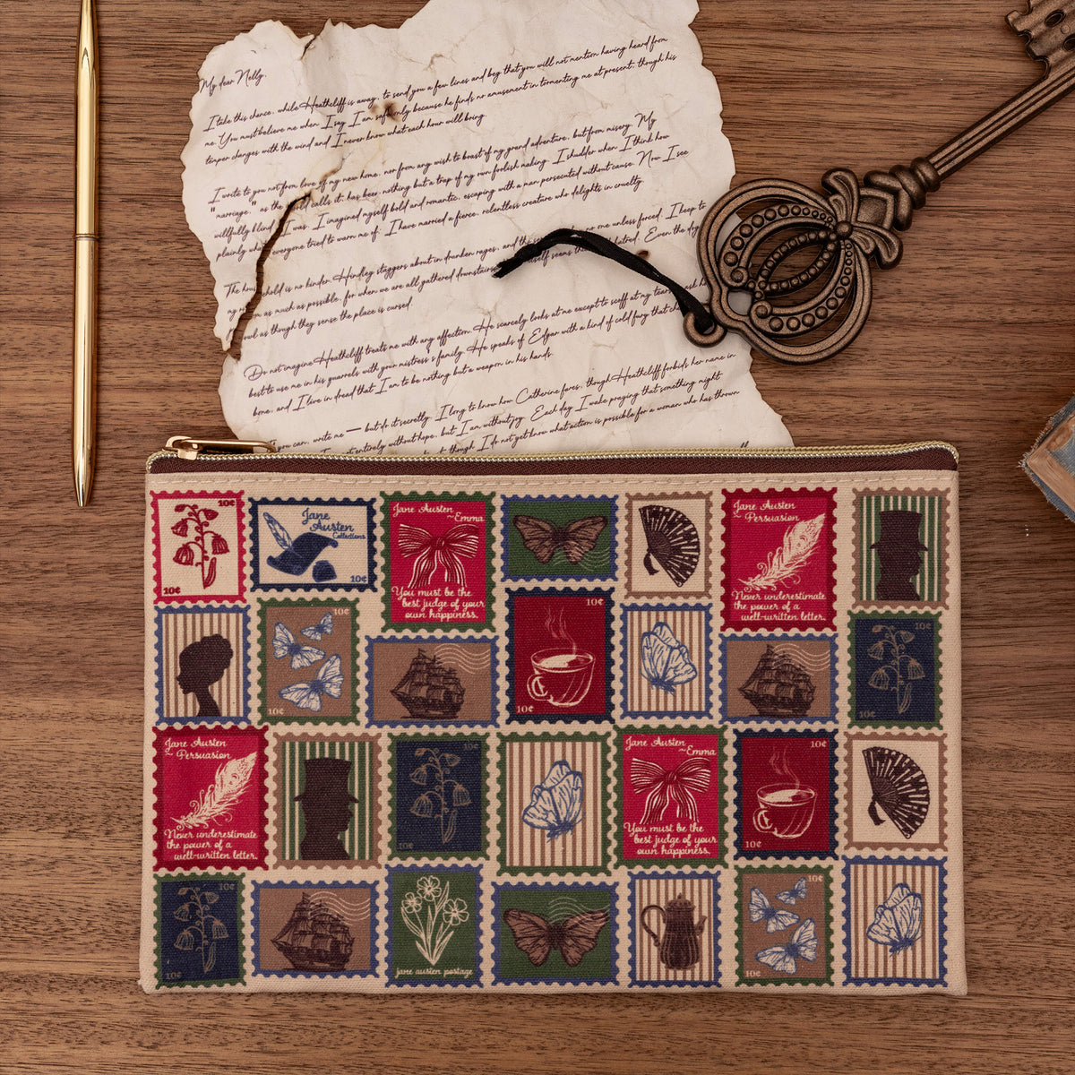A rectangular zippered pouch with a vintage postage stamp patchwork pattern in muted red, blue, green, and beige tones, featuring illustrations of butterflies, teacups, books, and feathers