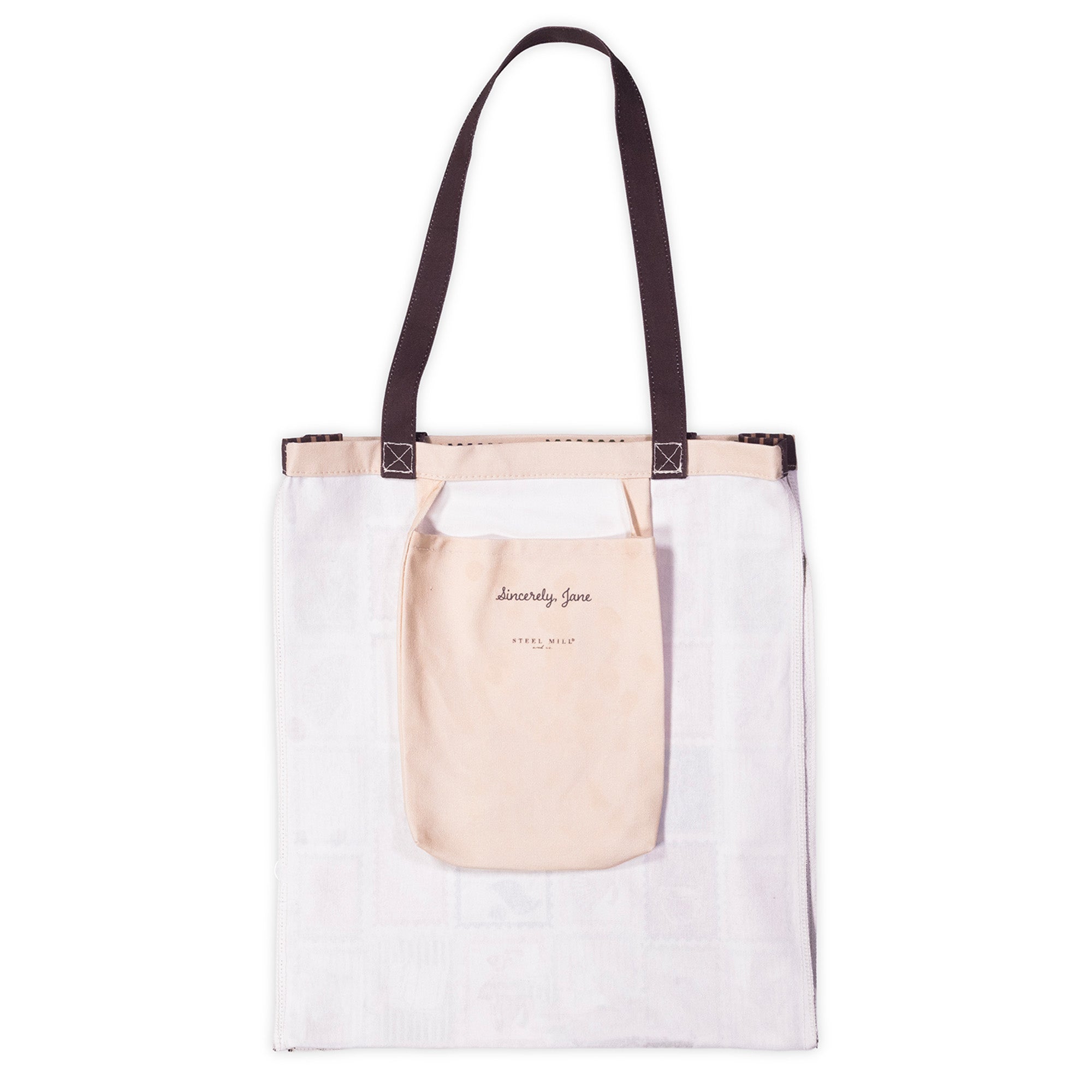 A white canvas tote bag with dark brown shoulder straps, featuring a front pocket in a light blush pink color with the text 'Sincerely Jane' printed on it.