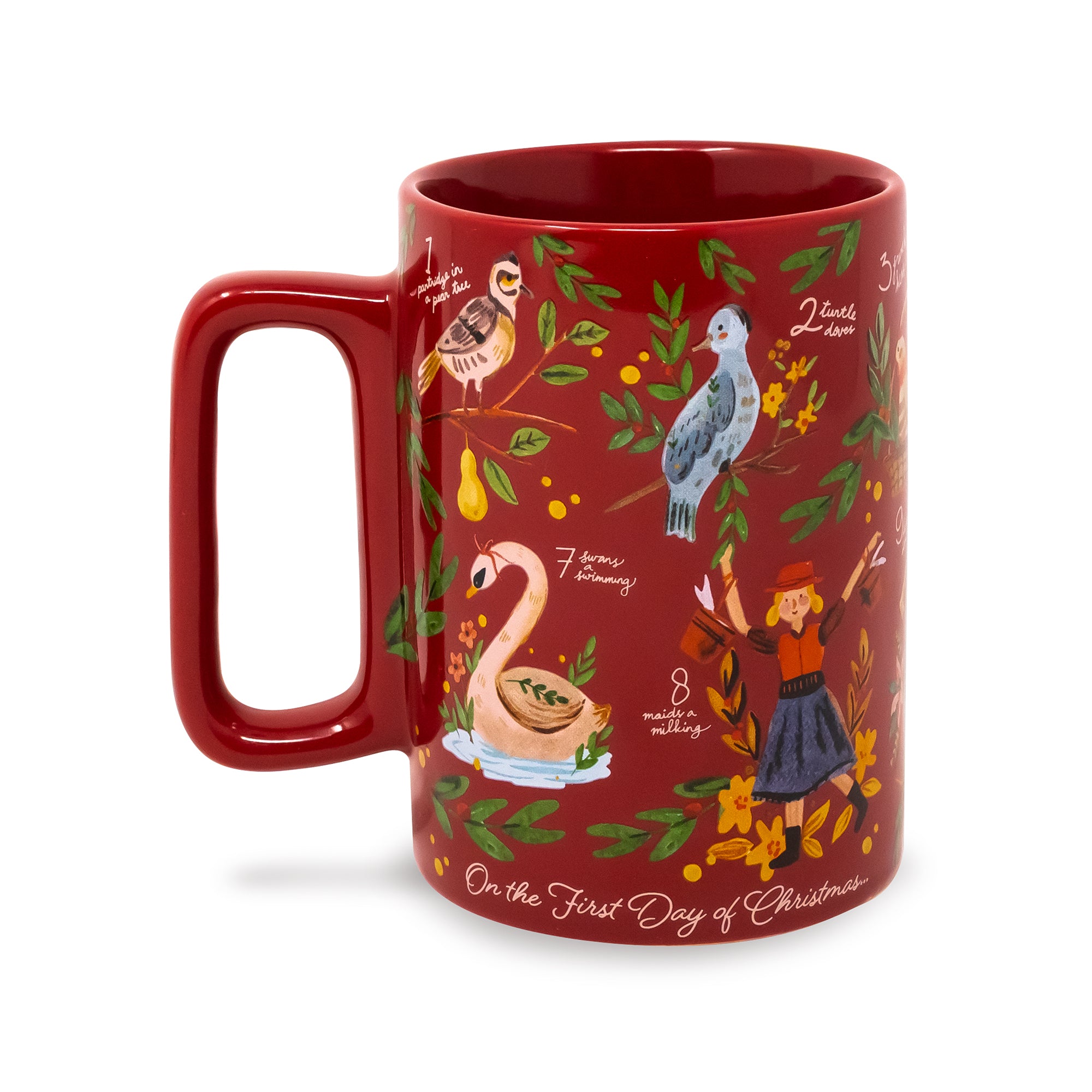 A red ceramic mug decorated with Christmas-themed illustrations, including a swan, a bird, a girl, and text reading 'On the First Day of Christmas'.