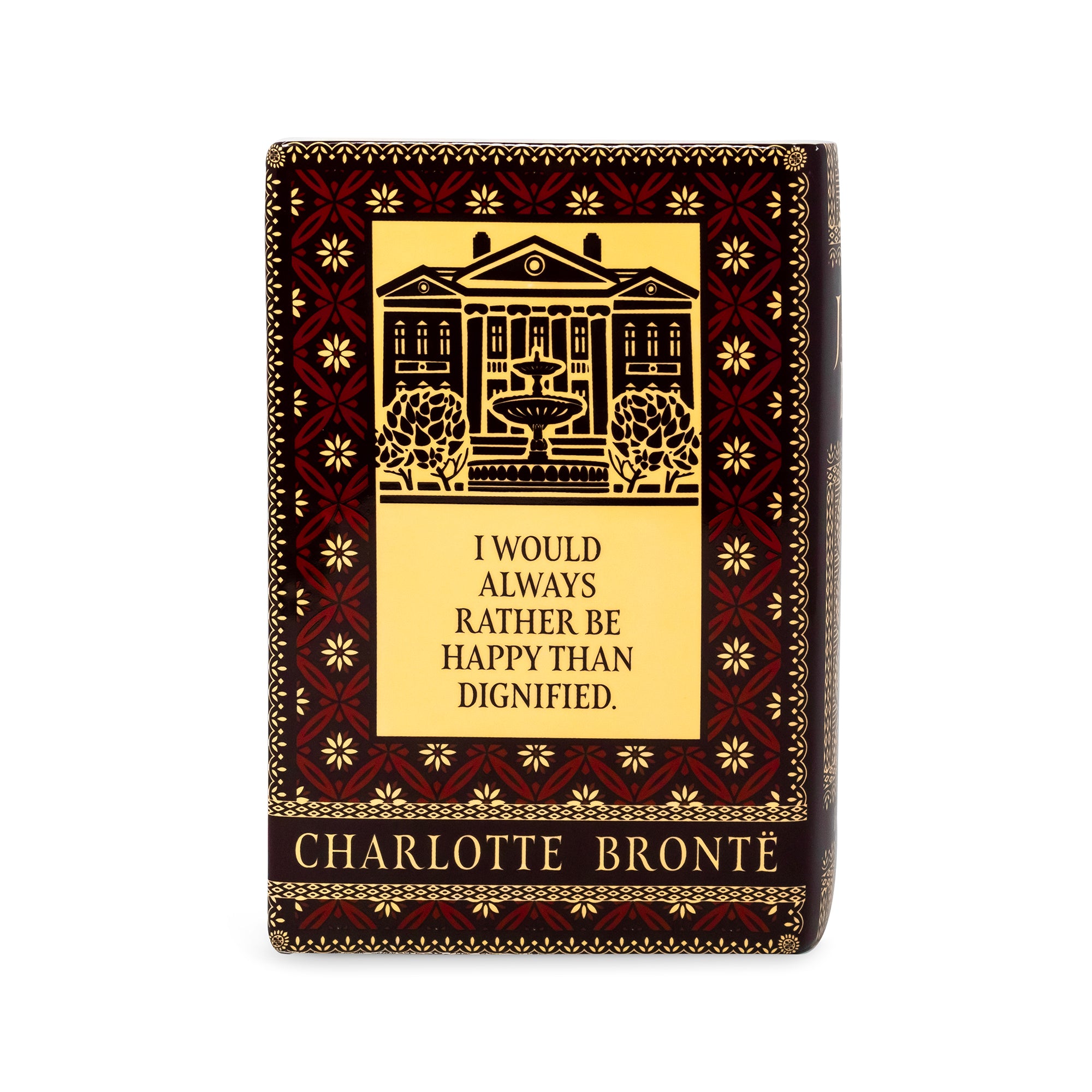 A Charlotte Bronté book-style box or plaque with a dark red and gold ornamental border, a central illustration of a building with a fountain, and the quote 'I WOULD ALWAYS RATHER BE HAPPY THAN DIGNIFIED.' on a plain white background.