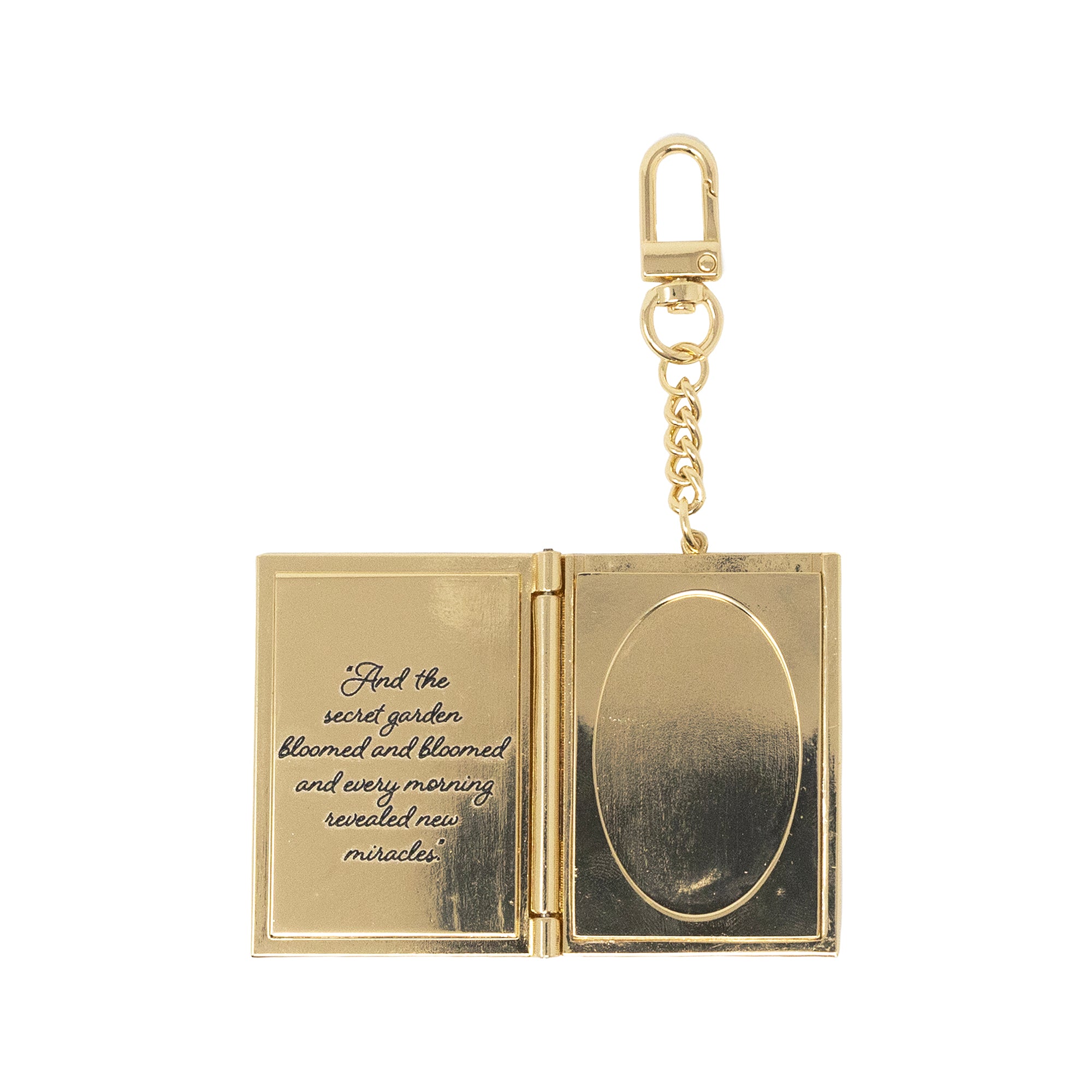 Gold book-shaped keychain with a quote on a white background