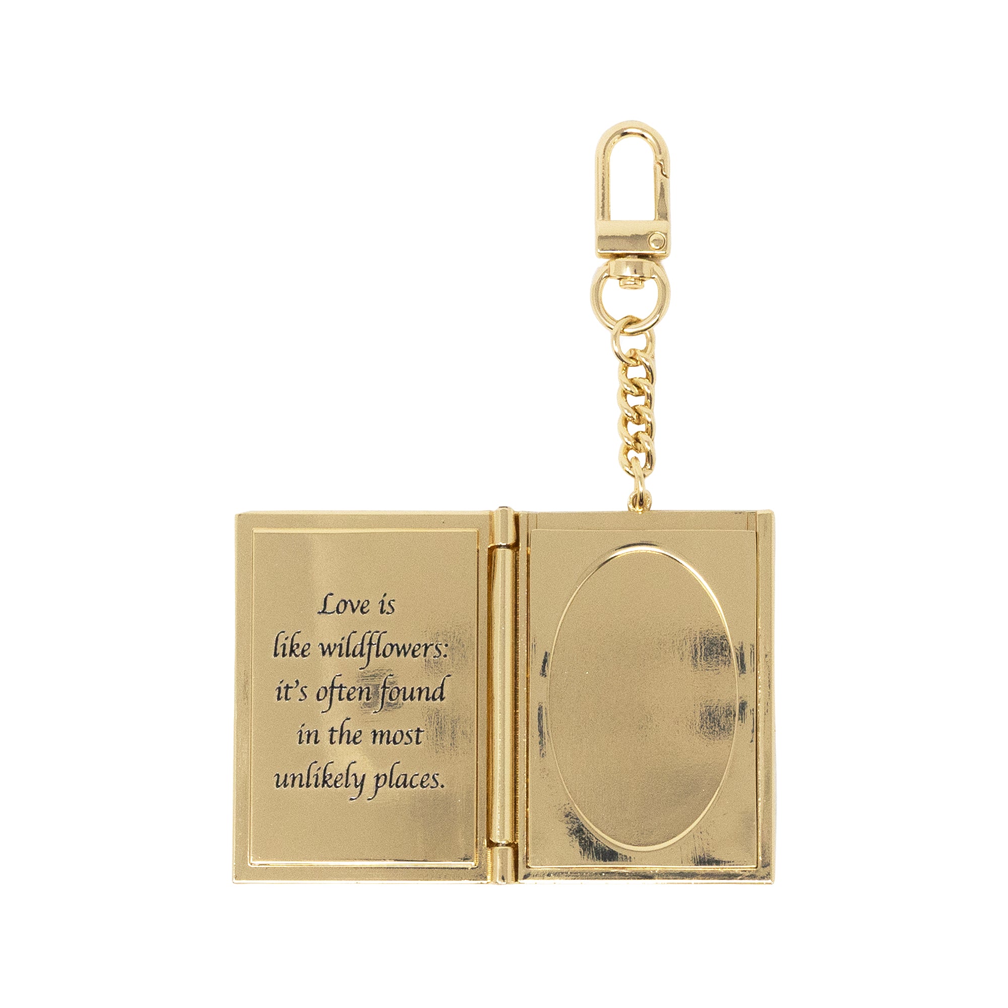 Gold keychain with open book design and engraved text on a white background