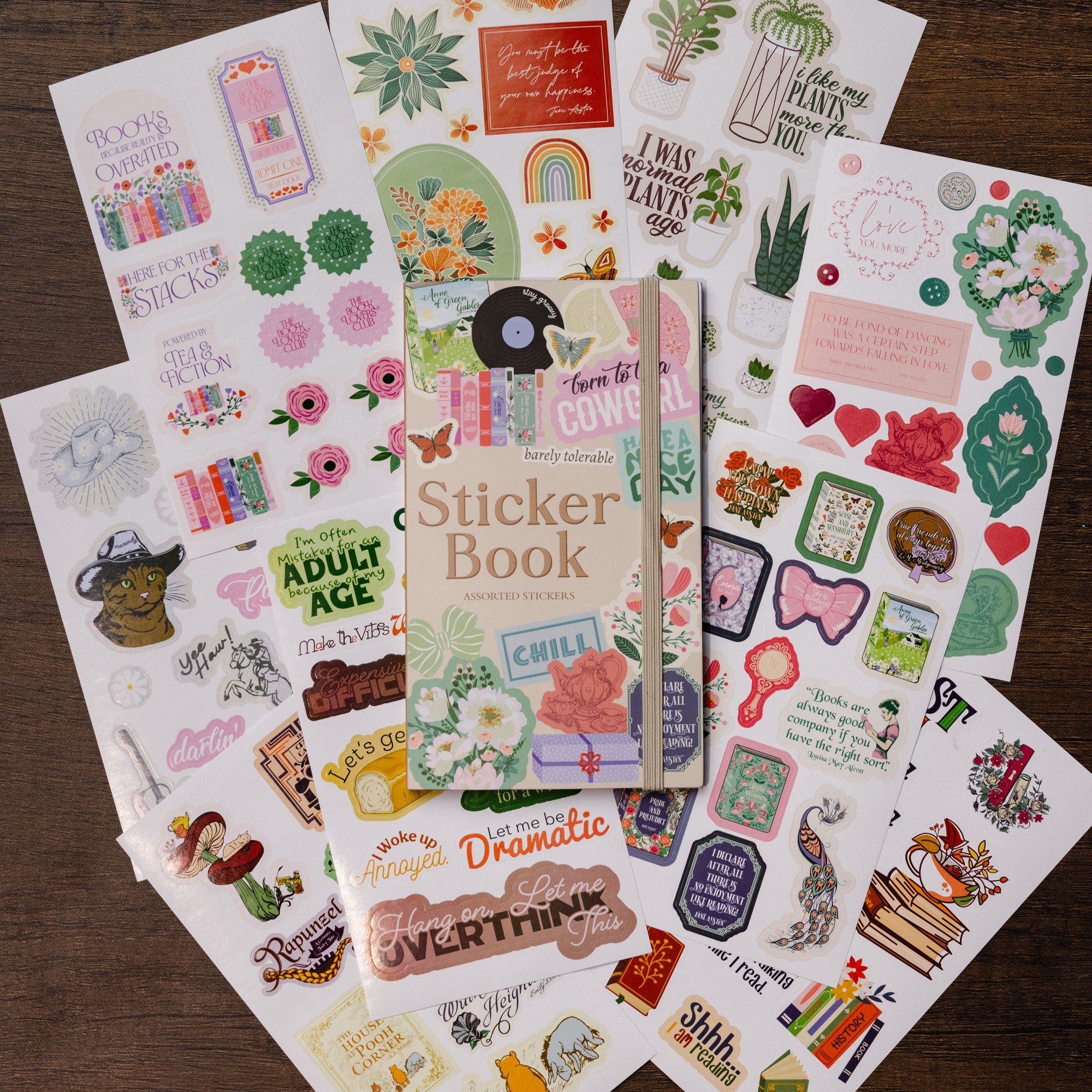 Collection of colorful stickers and a sticker book on a wooden surface