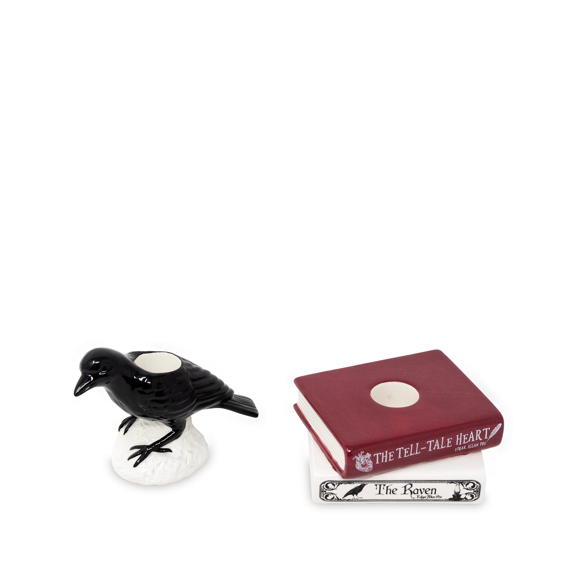 A black raven figurine on a white base next to a small red book labeled 'The Tell-Tale Heart' and a white book labeled 'The Raven' on a plain white background.