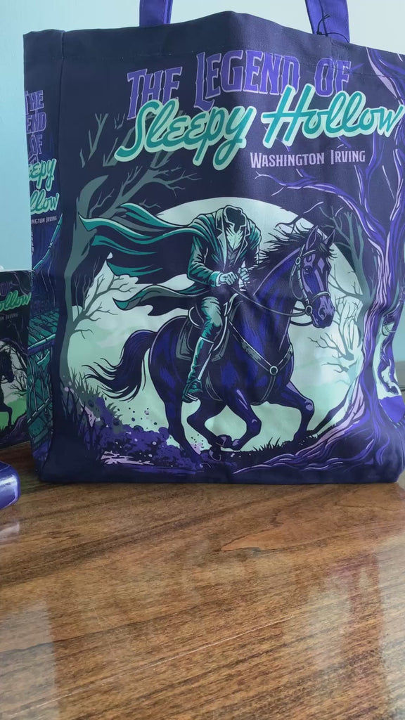 model showcasing dark tote bag with purple handles and a graphic print of a ghostly rider on a horse in a spooky forest, featuring the text 'The Legend of Sleepy Hollow' and 'Washington Irving'.