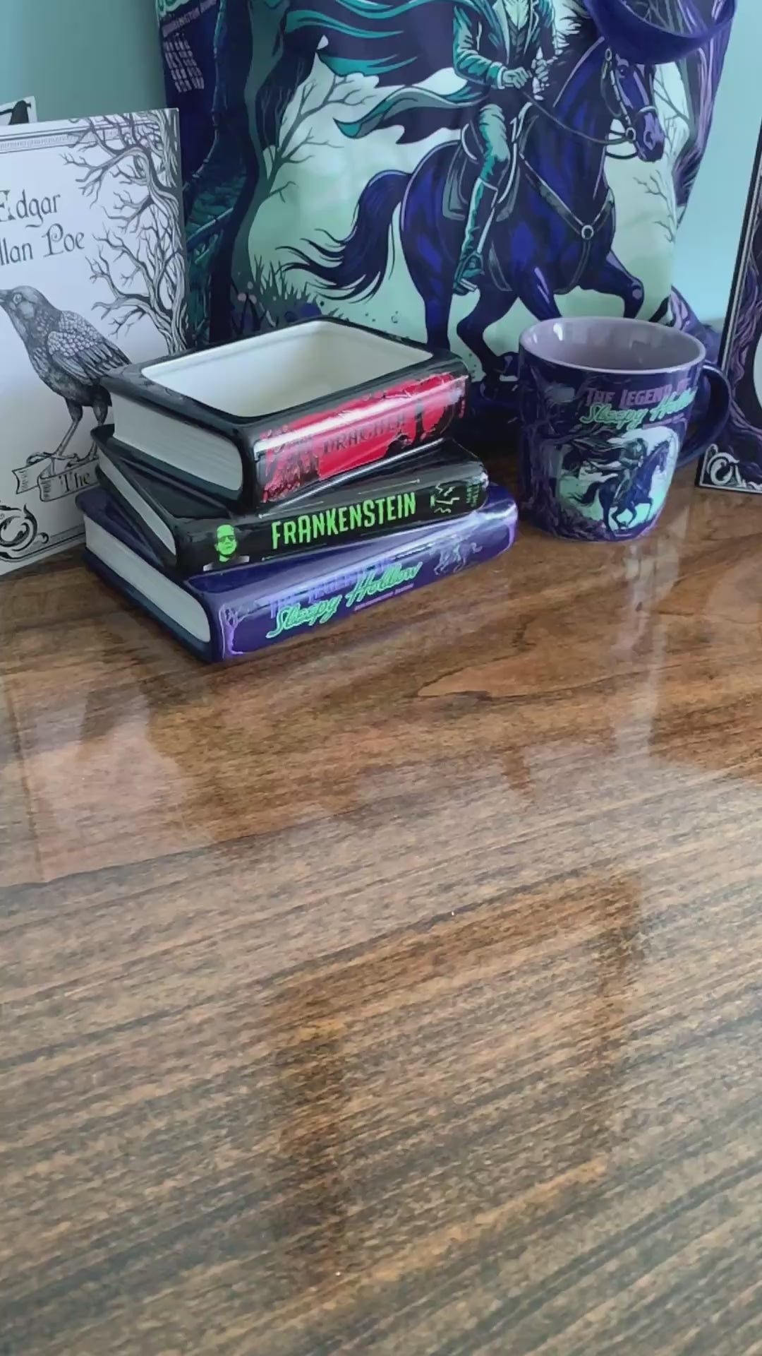 model showcasing square ceramic vase featuring 'The Legend of Sleepy Hollow' artwork, with a dark purple and black background, green and purple text, and a graphic of a ghostly figure on a horse.
