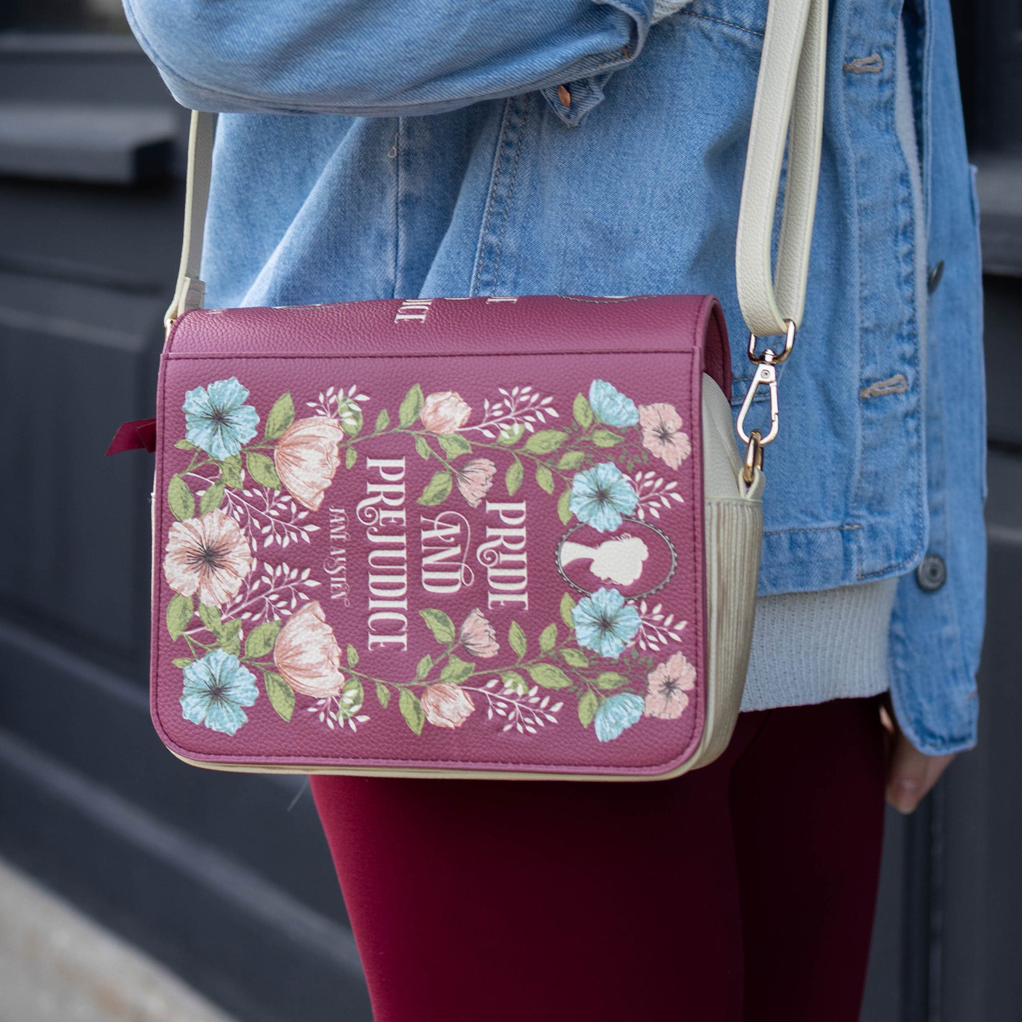 Handbag with 'Pride and Prejudice' design held by a person wearing a blue jacket.