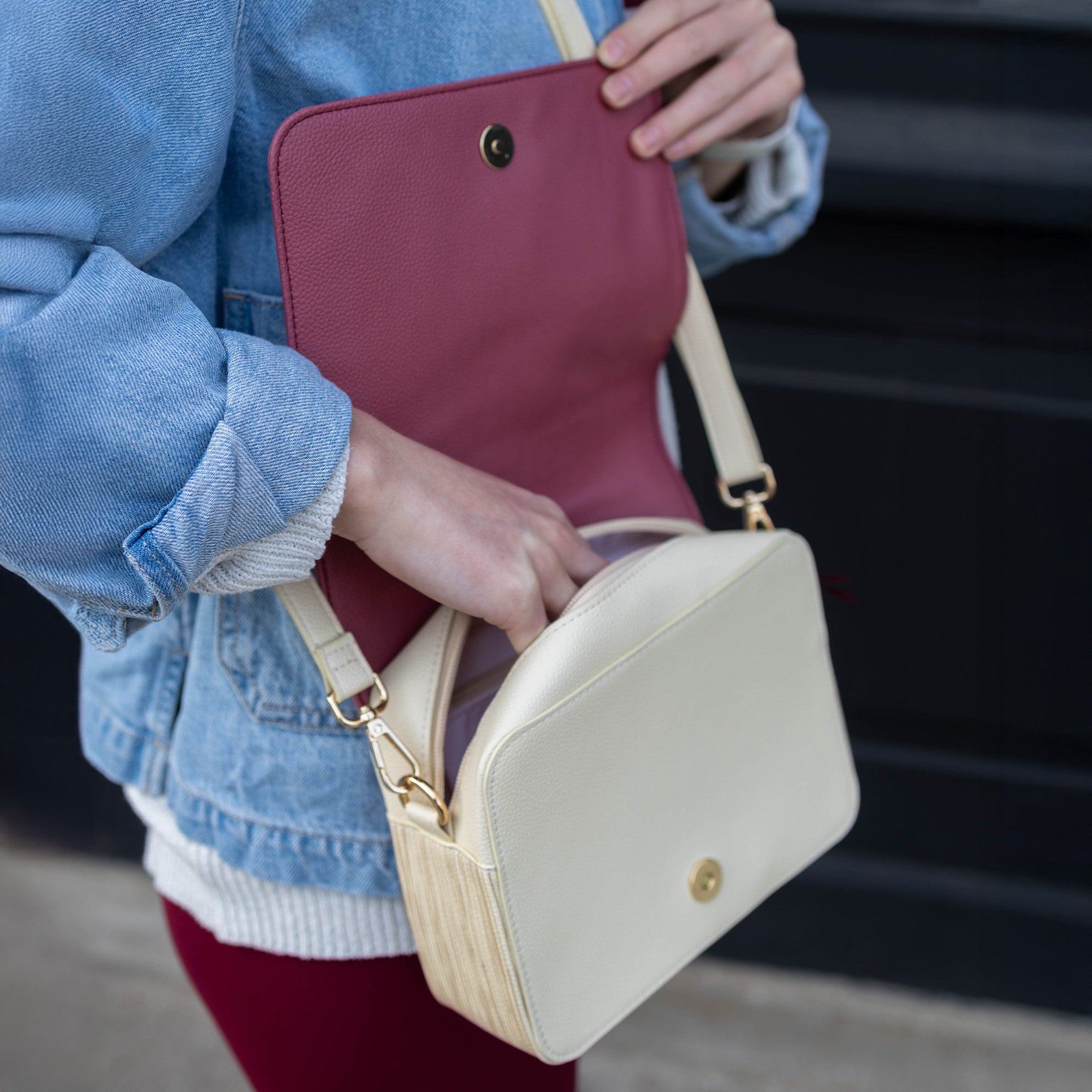 Person holding a beige handbag with a red interior